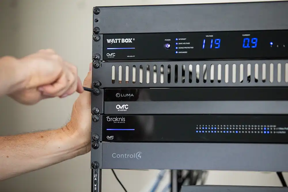 A man is working on a rack-mounted home entertainment system of a Chicago North Shore luxury home.